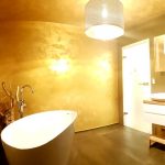 Badezimmer mit Wanne und Waschbecken in goldenem Licht