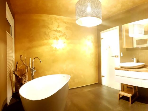 Badezimmer mit Wanne und Waschbecken in goldenem Licht